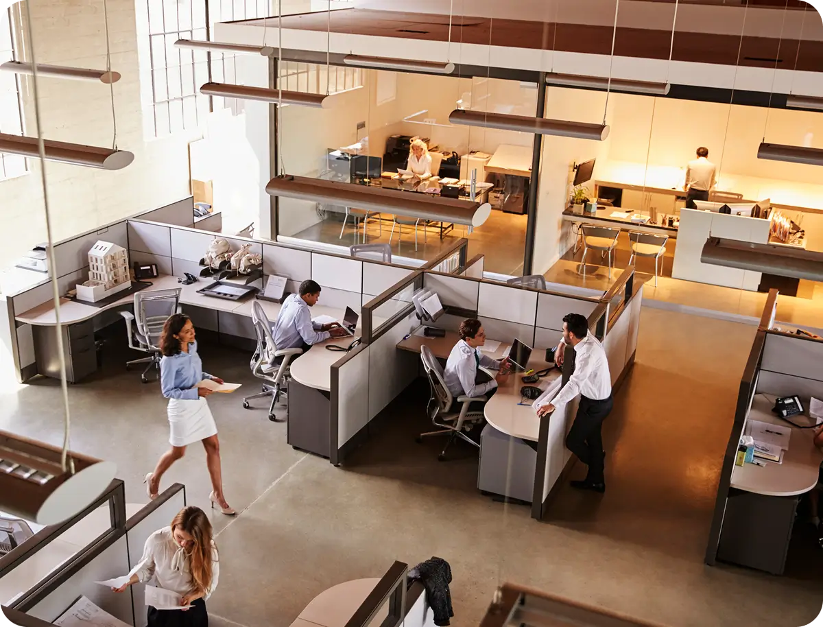 Modern office space with employees collaborating and working at desks.